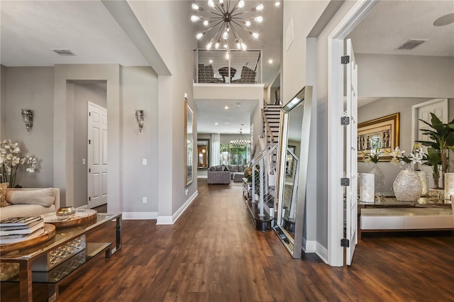 entrance foyer featuring dark hardwood / wood-style flooring, a chandelier, and a high ceiling