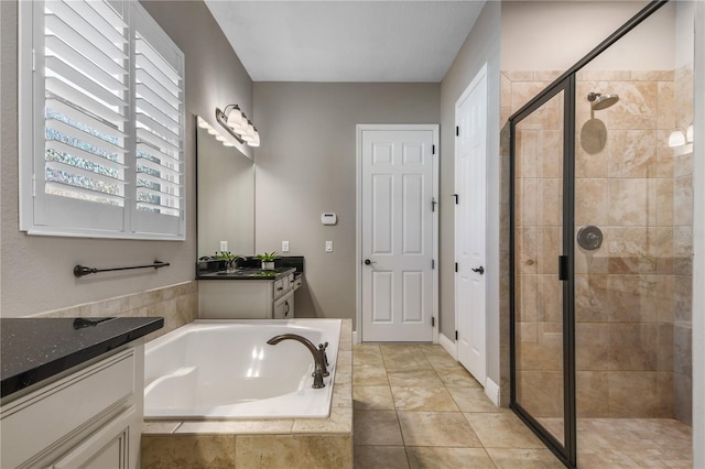 full bathroom featuring a stall shower, tile patterned flooring, a bath, and vanity