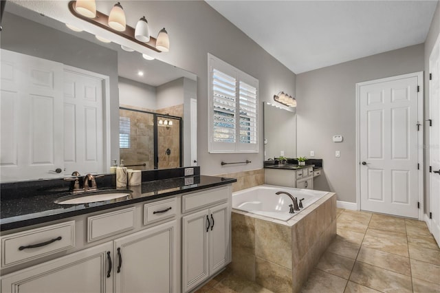 full bathroom with two vanities, a stall shower, a sink, a bath, and tile patterned floors