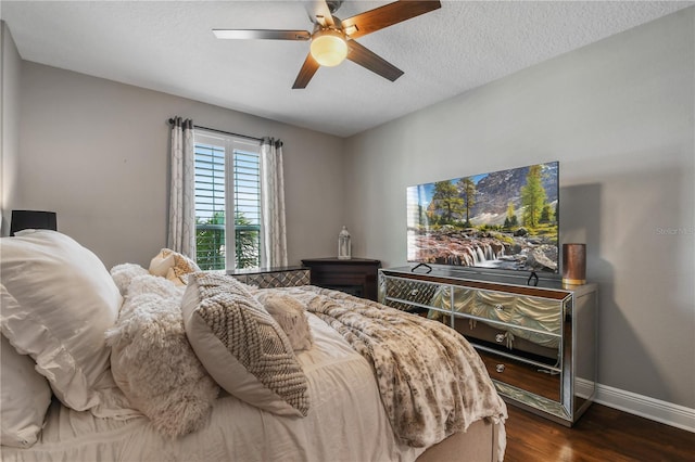 bedroom with a textured ceiling, dark wood finished floors, a ceiling fan, and baseboards