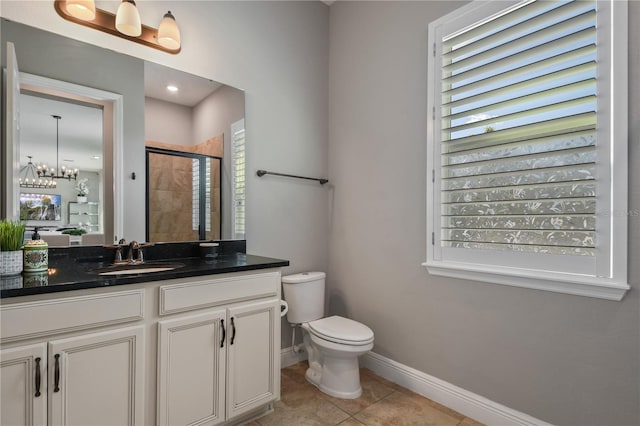 bathroom with toilet, vanity, baseboards, tile patterned floors, and a stall shower