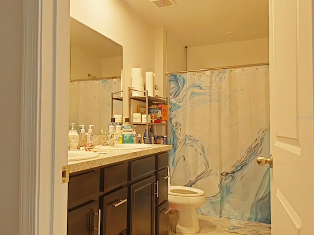 bathroom with tile patterned flooring, toilet, and double sink vanity