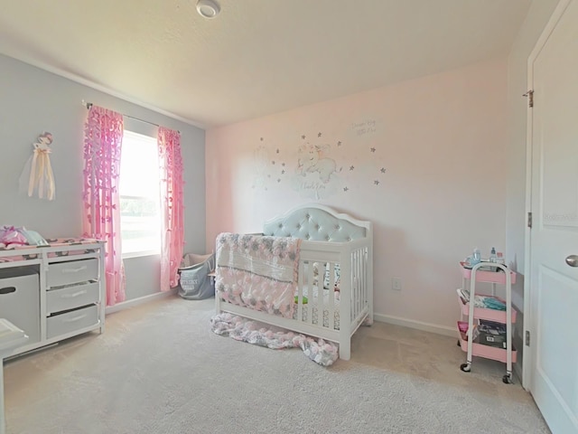 carpeted bedroom with a nursery area