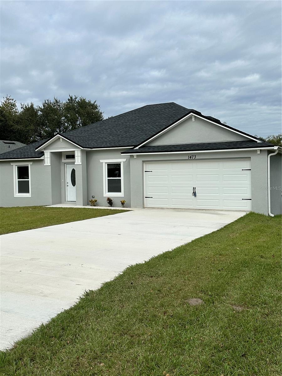 ranch-style house with a garage and a front yard