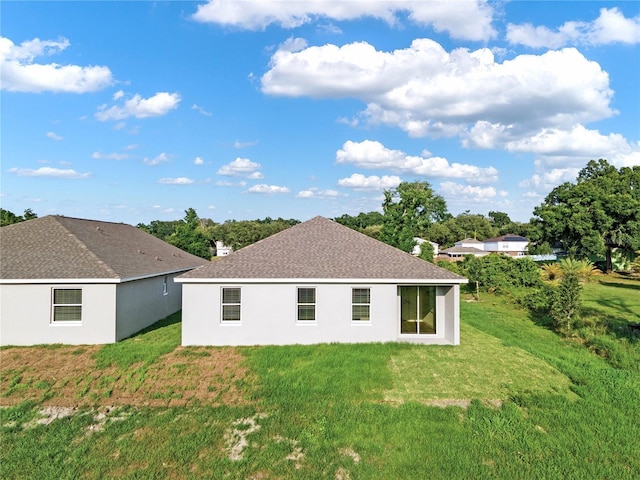 rear view of property featuring a yard