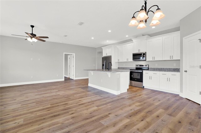 kitchen featuring stainless steel appliances, white cabinets, pendant lighting, light hardwood / wood-style floors, and ceiling fan with notable chandelier