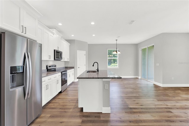 kitchen with white cabinets, stainless steel appliances, sink, an island with sink, and wood-type flooring