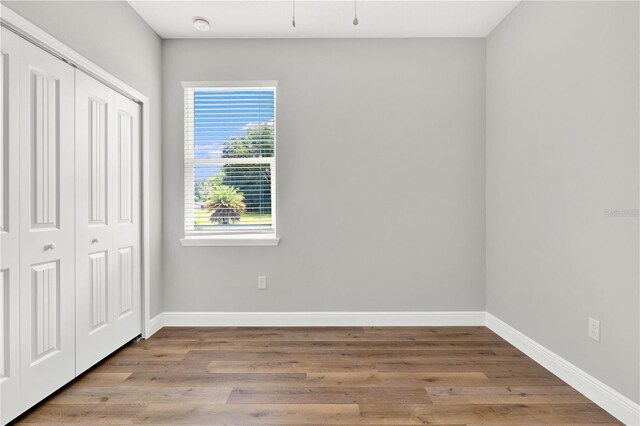 unfurnished bedroom with hardwood / wood-style flooring and a closet