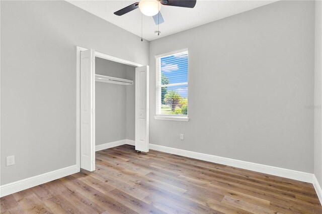 unfurnished bedroom with hardwood / wood-style flooring, a closet, and ceiling fan