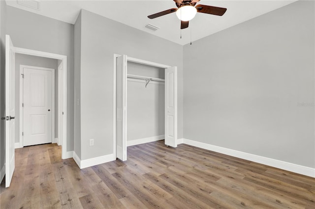 unfurnished bedroom featuring a closet, hardwood / wood-style floors, and ceiling fan