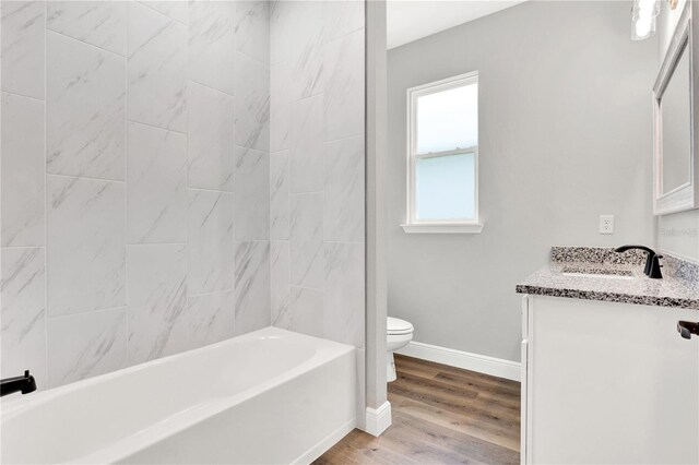 full bathroom with vanity, a healthy amount of sunlight, toilet, and hardwood / wood-style floors