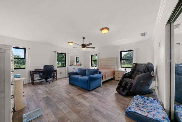 living room featuring ceiling fan, light hardwood / wood-style flooring, and crown molding