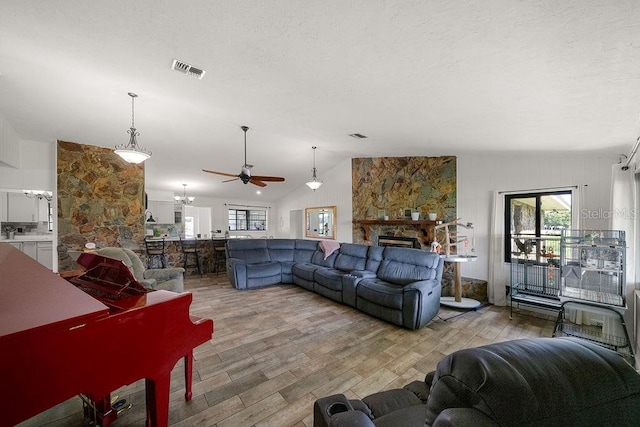 living room with a fireplace, light wood-type flooring, and vaulted ceiling