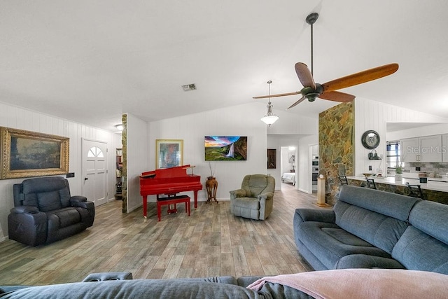 living room with light hardwood / wood-style floors, lofted ceiling, and ceiling fan