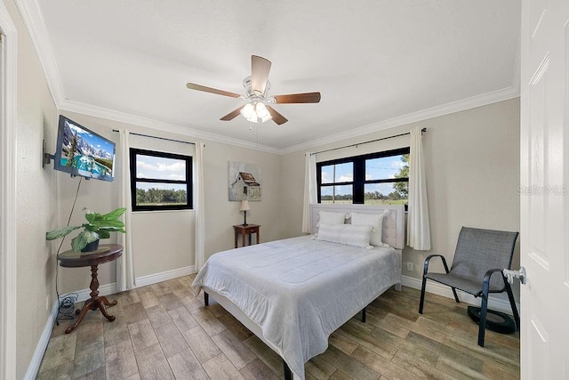 bedroom featuring ceiling fan, crown molding, and multiple windows