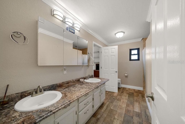 bathroom with hardwood / wood-style flooring, toilet, vanity, and ornamental molding