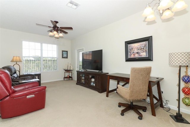 carpeted living room with ceiling fan with notable chandelier