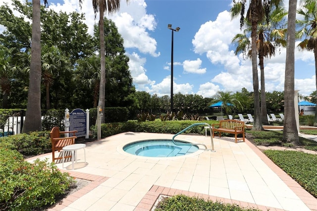 view of swimming pool featuring a patio area and a hot tub