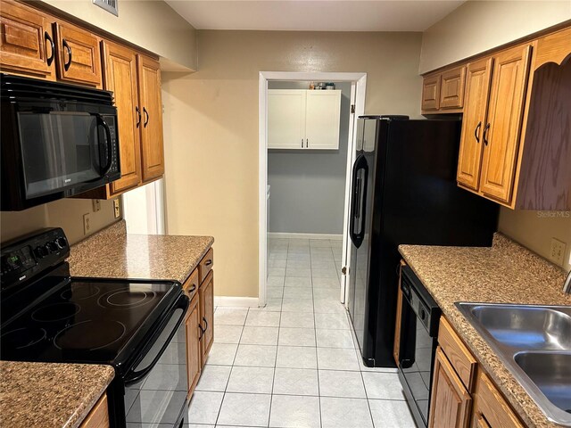 kitchen with sink, black appliances, and light tile patterned floors