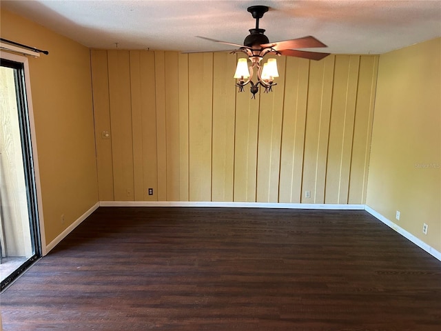 unfurnished room with ceiling fan, dark hardwood / wood-style flooring, and a textured ceiling