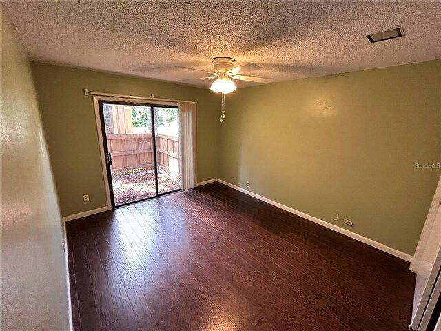 empty room with a textured ceiling, ceiling fan, and dark hardwood / wood-style floors