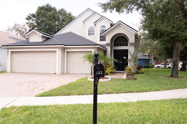 view of property with a front yard and a garage