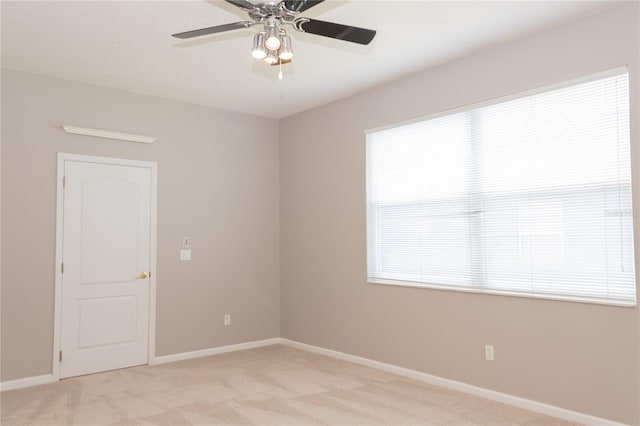 carpeted spare room featuring ceiling fan