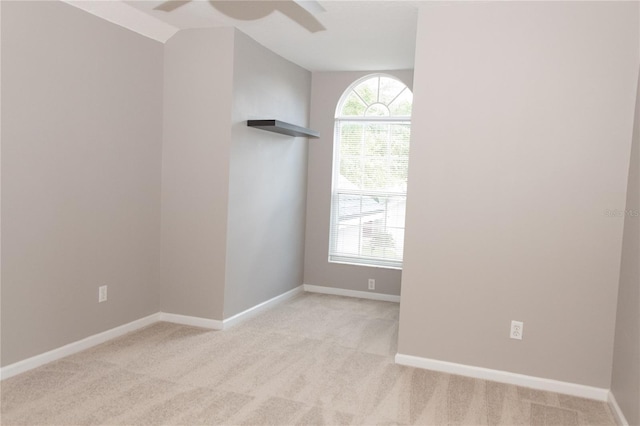 unfurnished room featuring light carpet, vaulted ceiling, and plenty of natural light