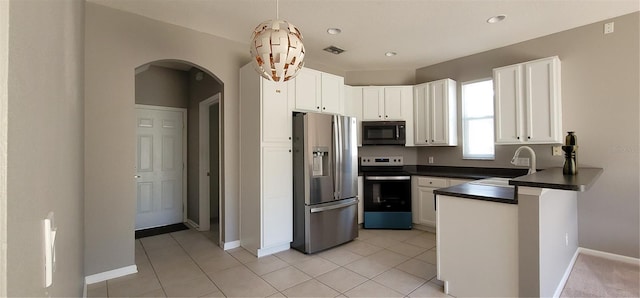 kitchen with appliances with stainless steel finishes, sink, light tile patterned floors, decorative light fixtures, and white cabinets