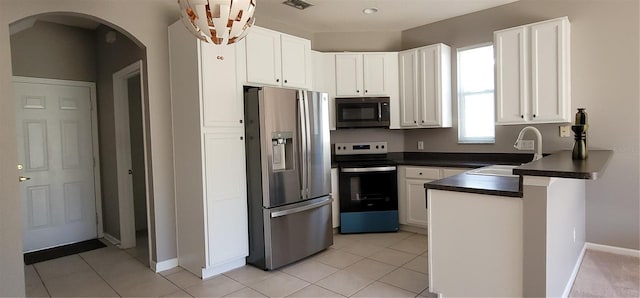 kitchen with sink, white cabinets, light tile patterned floors, and appliances with stainless steel finishes