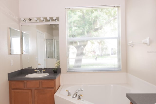 bathroom with vanity, separate shower and tub, and a wealth of natural light