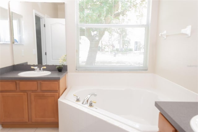 bathroom featuring vanity and a relaxing tiled tub