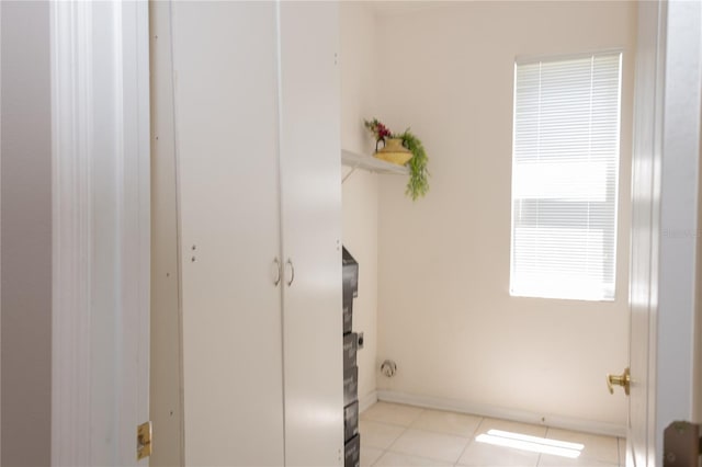 clothes washing area featuring light tile patterned floors