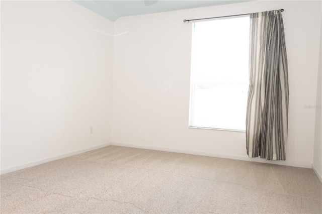 carpeted spare room featuring a wealth of natural light