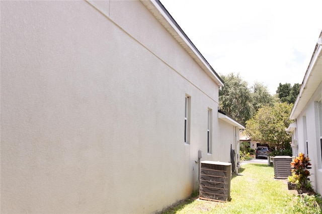 view of side of property with a lawn and central air condition unit