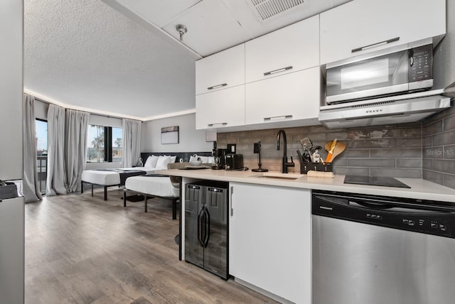 kitchen featuring sink, hardwood / wood-style flooring, backsplash, and stainless steel appliances