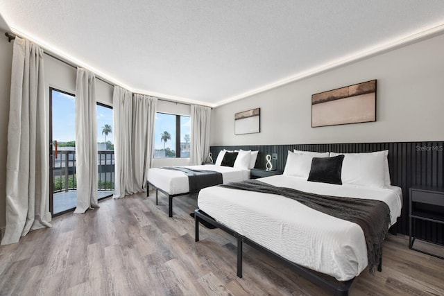 bedroom featuring a textured ceiling, wood finished floors, and access to outside