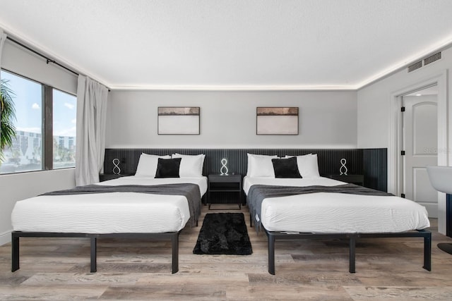 bedroom featuring wood finished floors and visible vents