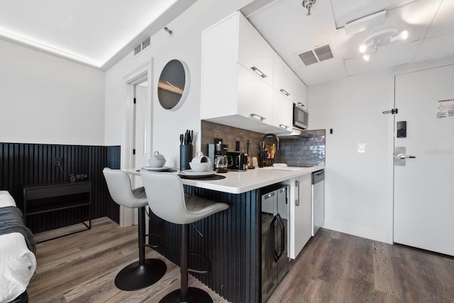 kitchen featuring tasteful backsplash, stainless steel appliances, white cabinets, sink, and dark hardwood / wood-style flooring