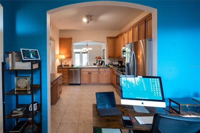 kitchen featuring appliances with stainless steel finishes, sink, a chandelier, hanging light fixtures, and light tile patterned floors