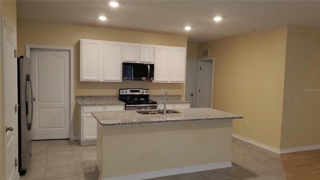 kitchen featuring sink, white cabinetry, a kitchen island with sink, stainless steel appliances, and light stone counters