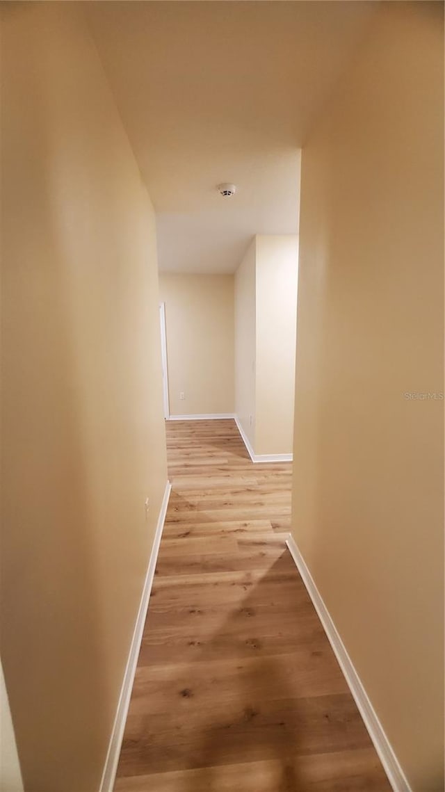 corridor with light hardwood / wood-style floors