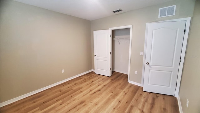 unfurnished bedroom featuring light wood-type flooring and a closet