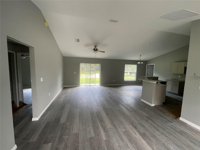 unfurnished living room with lofted ceiling, dark hardwood / wood-style floors, and ceiling fan