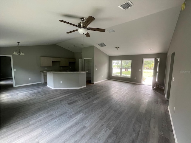 unfurnished living room with vaulted ceiling, ceiling fan with notable chandelier, and dark hardwood / wood-style flooring