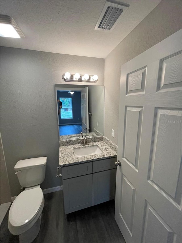 bathroom featuring vanity, hardwood / wood-style flooring, and toilet