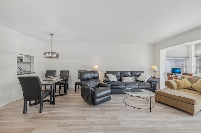 living room featuring a chandelier and light hardwood / wood-style flooring