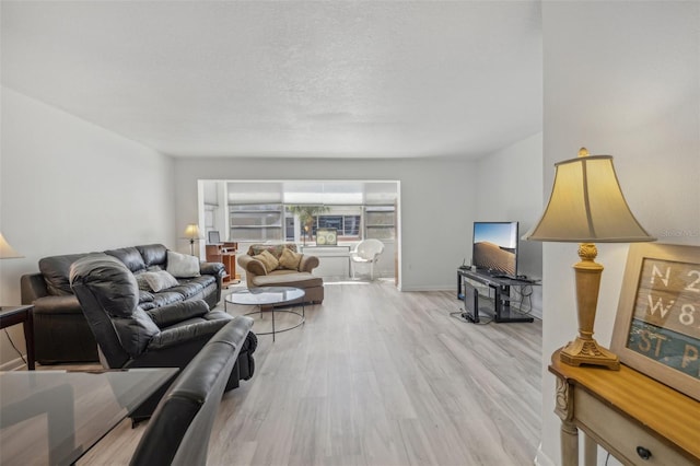 living room featuring a textured ceiling and light hardwood / wood-style floors