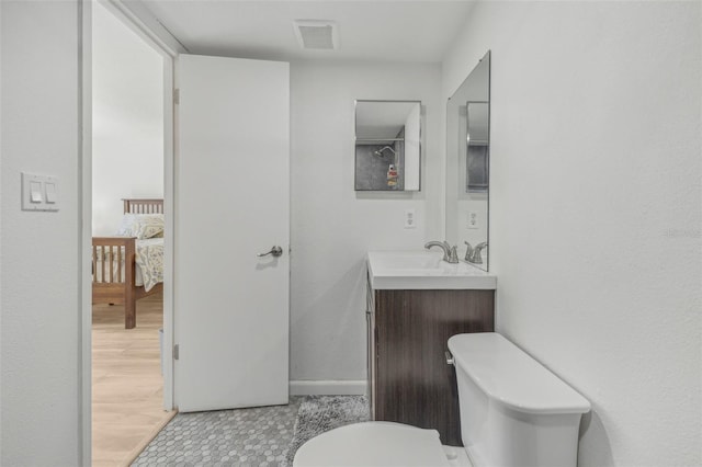 bathroom with toilet, vanity, and tile patterned floors