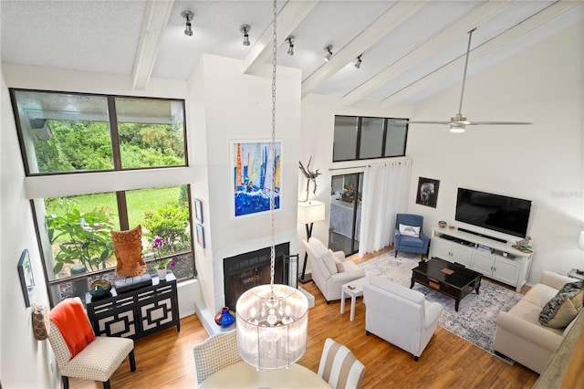 living room with high vaulted ceiling, plenty of natural light, and beamed ceiling